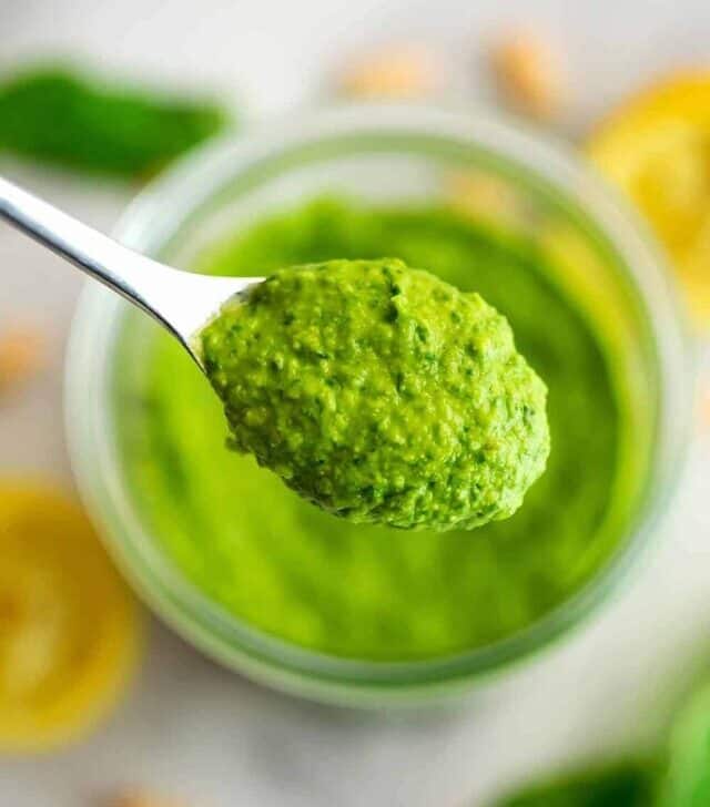 Spoonful of white bean pesto over a jar.