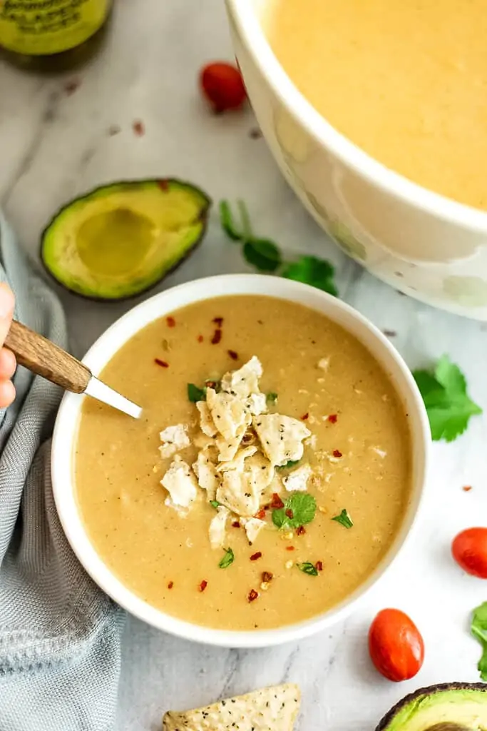 Bowl of Mexican cauliflower white bean soup topped with chips and cilantro.