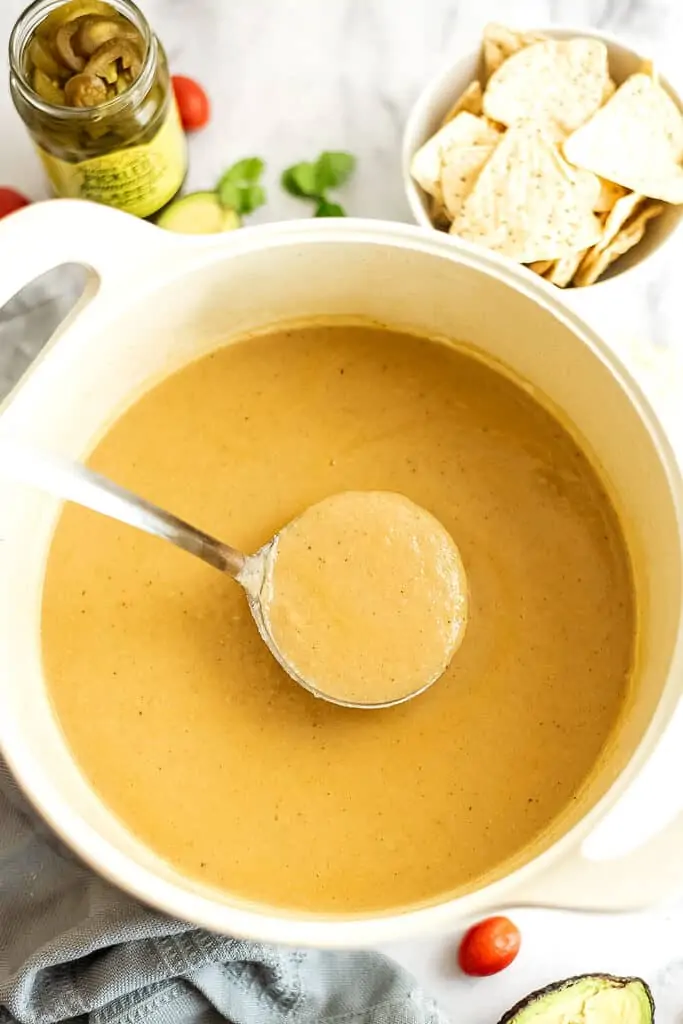 Ladle of cauliflower white bean soup over the pot.