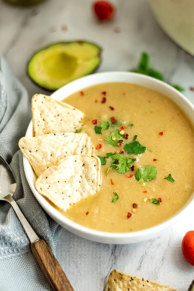 Tortilla chips in a bowl of Mexican cauliflower white bean soup.