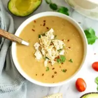 Bowl filled with cauliflower white bean soup with a spoon in the soup.