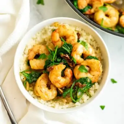 Bowl filled with sun dried tomato shrimp and cauliflower rice.
