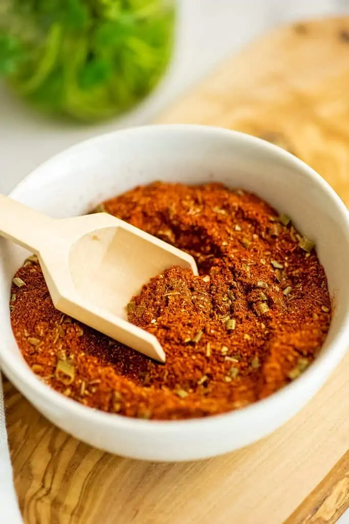 Wooden scoop in a bowl filled with Whole30 taco seasoning.