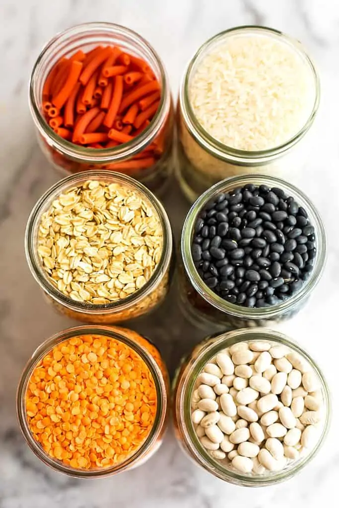 Glass jars filled with beans, rice and pasta.