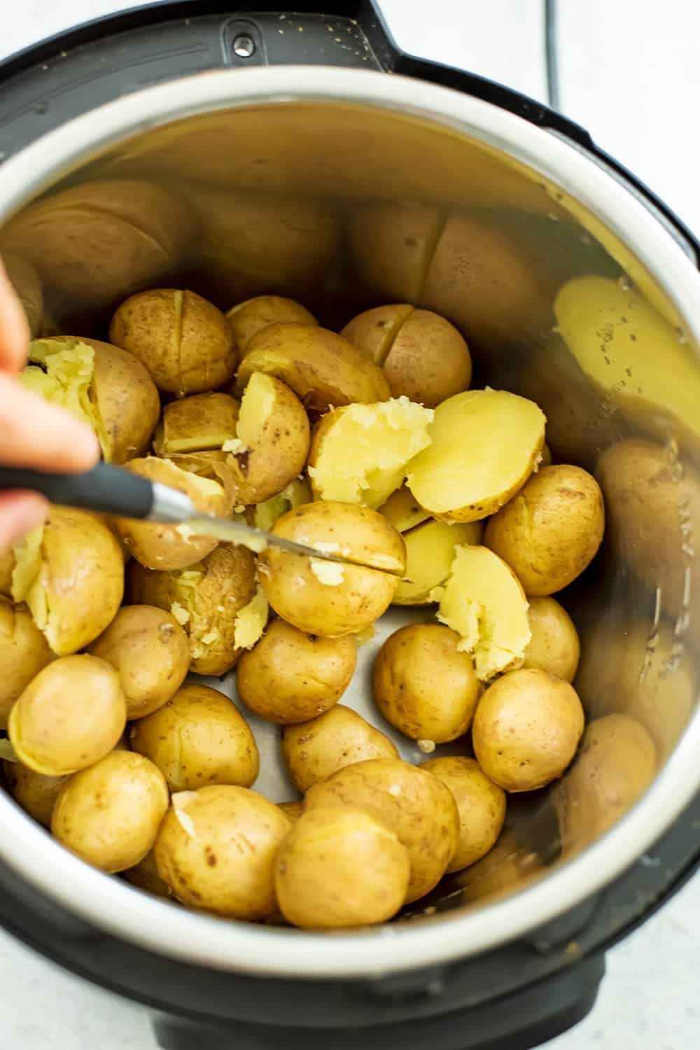 Knife cutting the potatoes in the instant pot.
