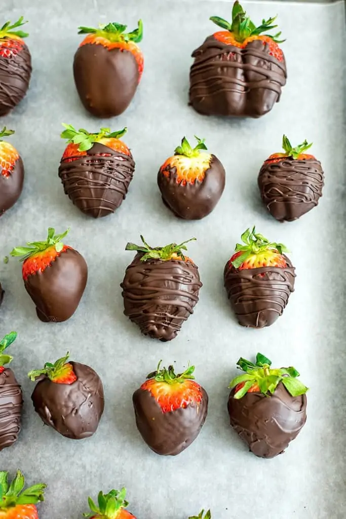 Vegan chocolate covered strawberries on a baking sheet.