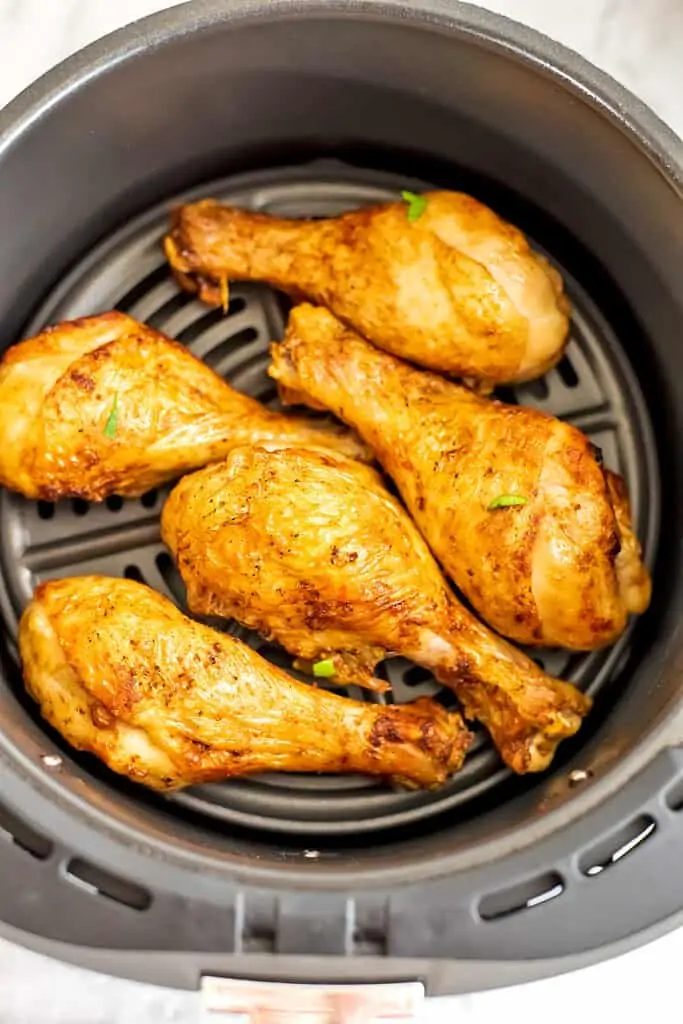 Chicken drumsticks in the air fryer basket.