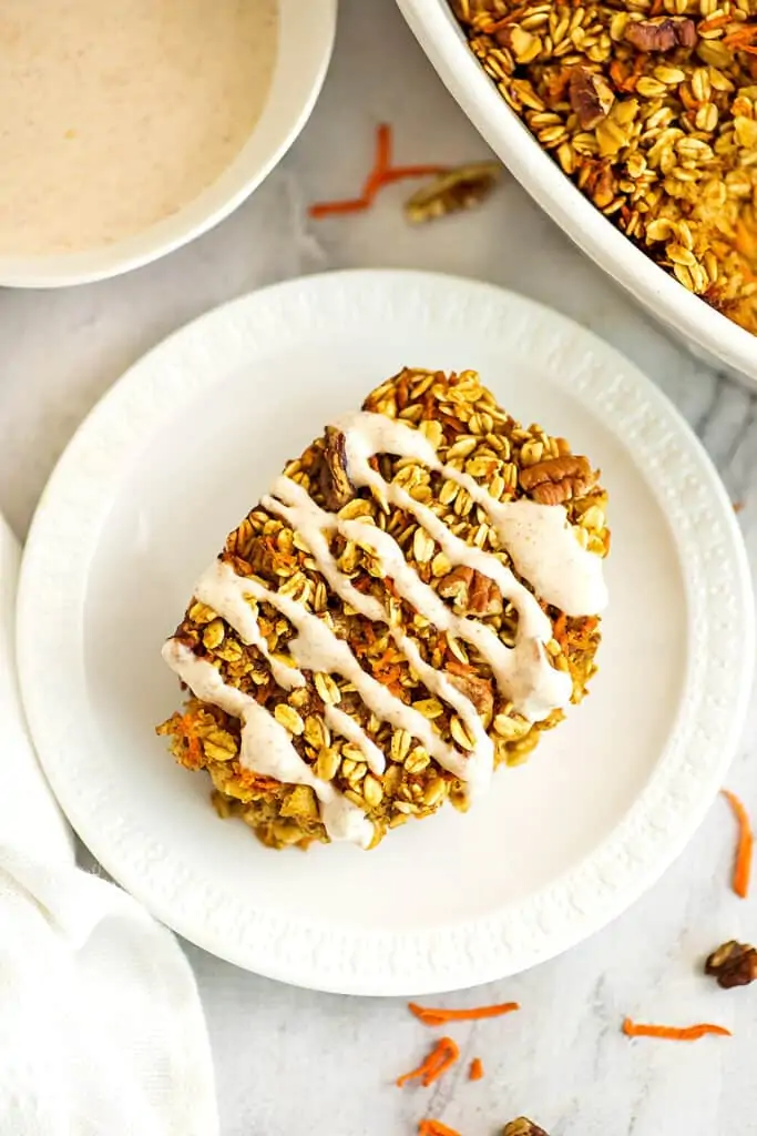 Carrot cake oatmeal bake with vegan frosting on a white plate