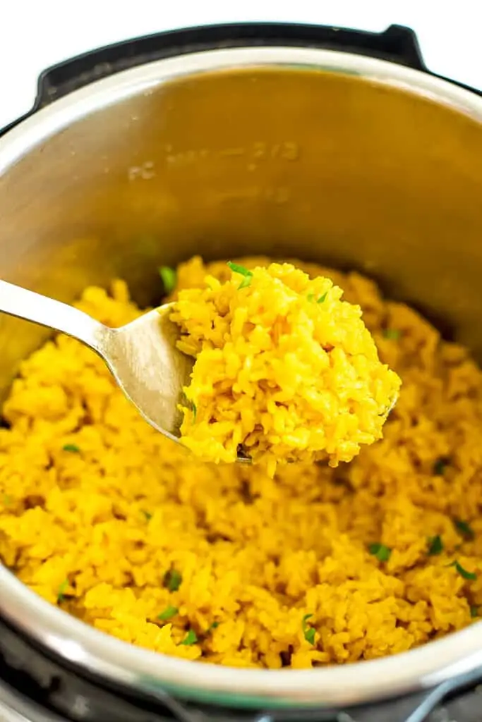 Lemon turmeric rice being scooped out of the instant pot.