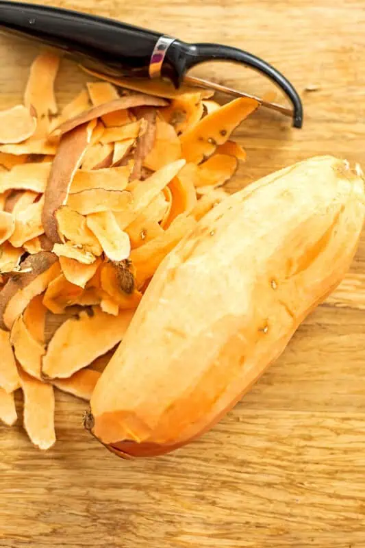 Peeled sweet potato on a cutting board.