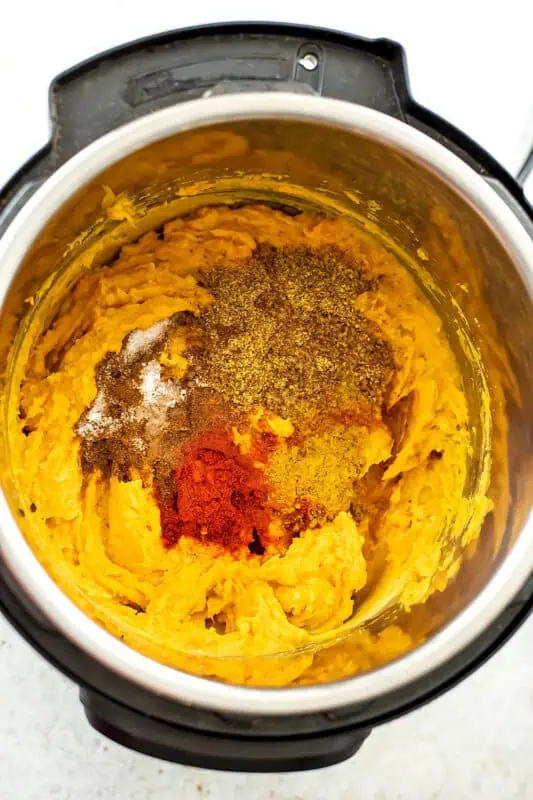 Spices added to instant pot with sweet potatoes and lentils.