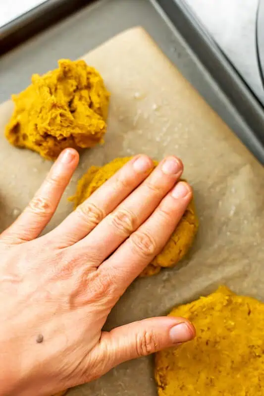 Hand flattening the sweet potato lentil patties.