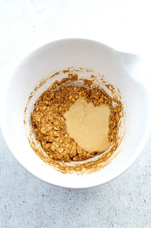 Tahini added to bowl with rolled oats.