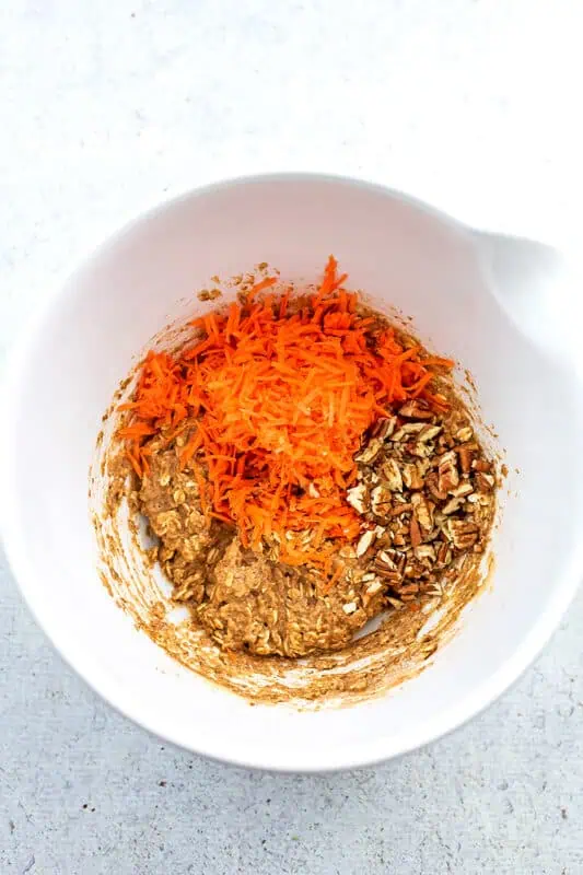 Shredded carrots added to bowl with the cookie dough.