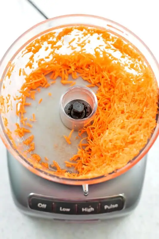 Shredded carrots in food processor.