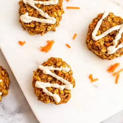 Vegan carrot cookies with cashew frosting on white tray.