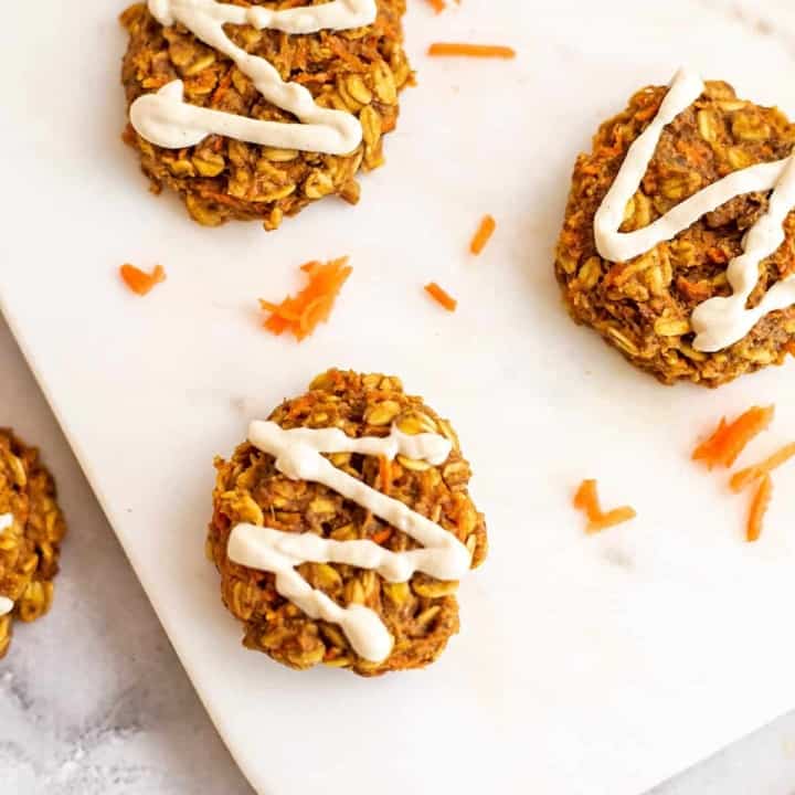 Vegan carrot cookies with cashew frosting on white tray.