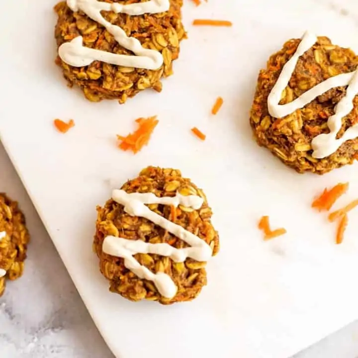 Vegan carrot cookies with cashew frosting on white tray.