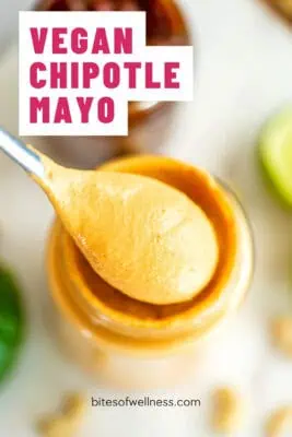 Spoonful of vegan chipotle mayo being lifted from a glass jar.
