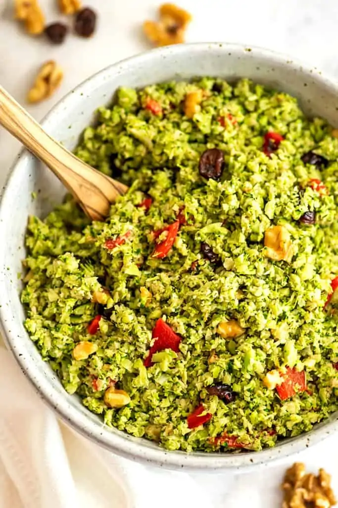 Large bowl filled with riced broccoli salad with cranberries.