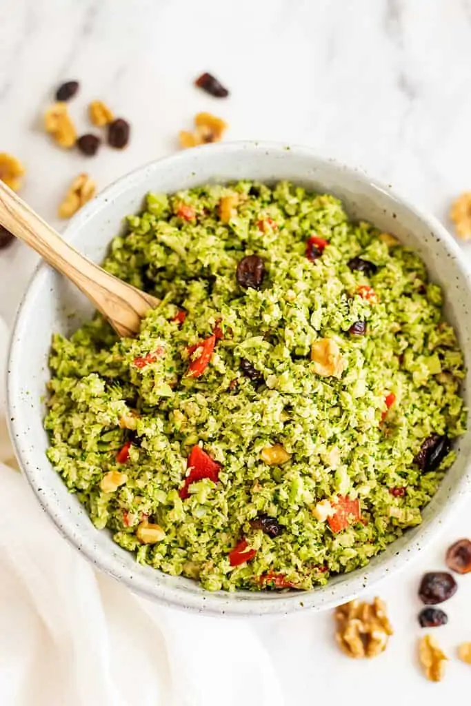 Spoon in a bowl of broccoli cranberry walnut salad.