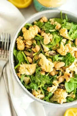 Roasted cauliflower salad with lemon tahini dressing in a bowl.