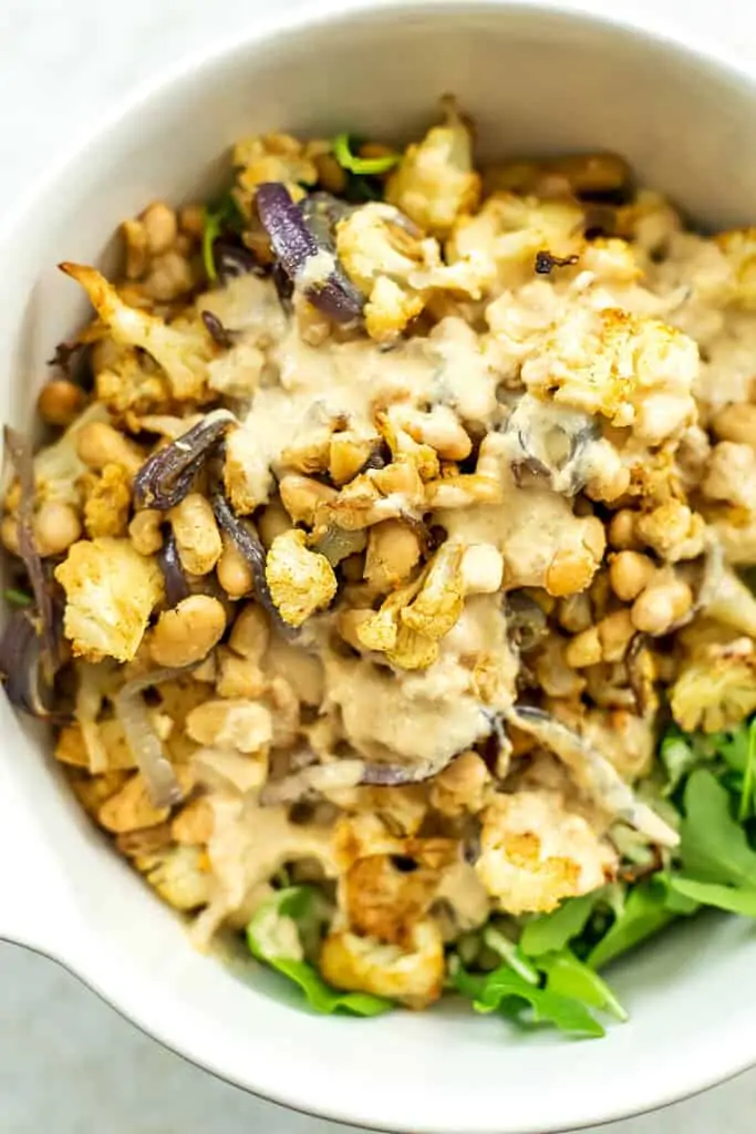 Roasted cauliflower, onions and beans over salad greens with lemon tahini dressing.