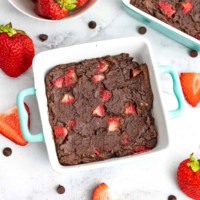 Square ramekin filled with single serve brownie with strawberries