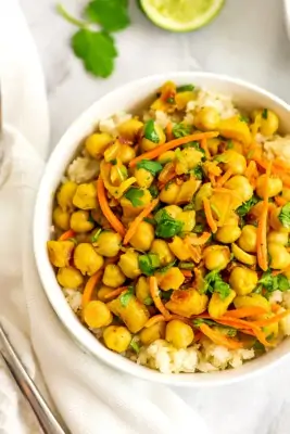 Apricot chickpea curry over cauliflower rice in bowl.