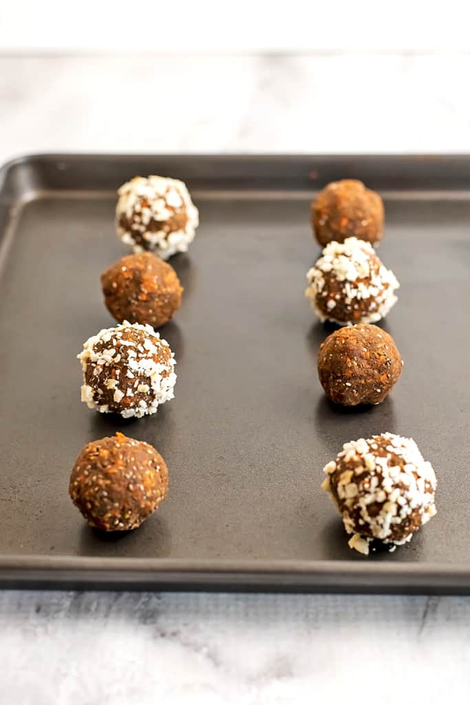 Carrot cake protein bites lined up on a baking sheet.