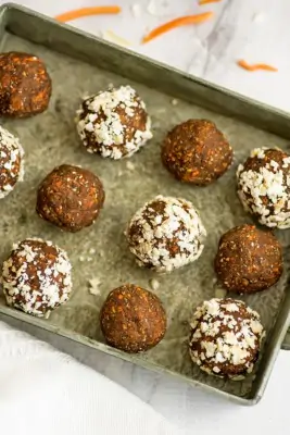 Carrot cake energy bites lined up on a tray.