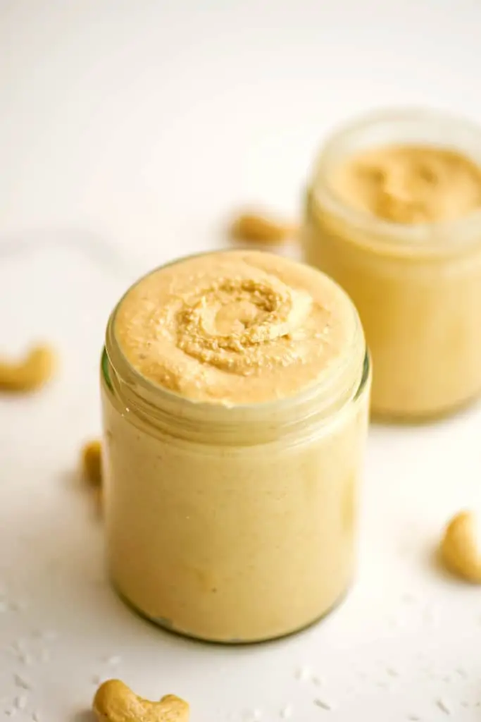 Jar full of cashew coconut butter with swirl on top.
