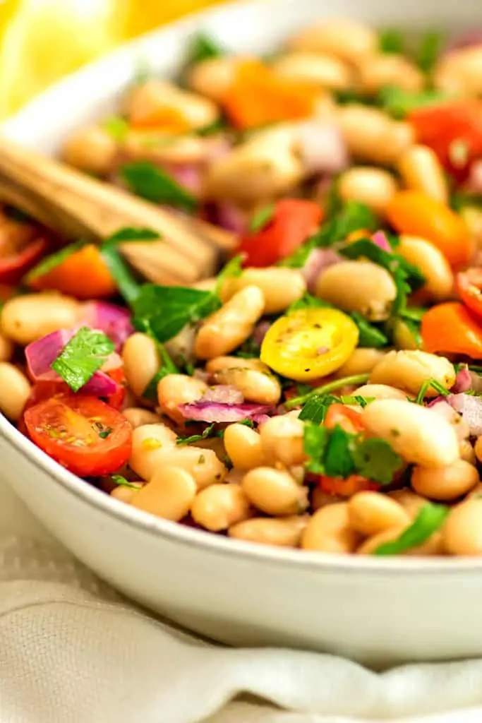 Mediterranean white bean salad in a white bowl.