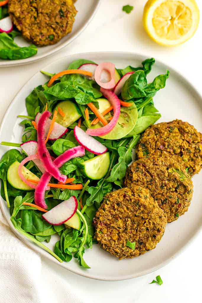 Plate of salad and 3 lentil falafels.