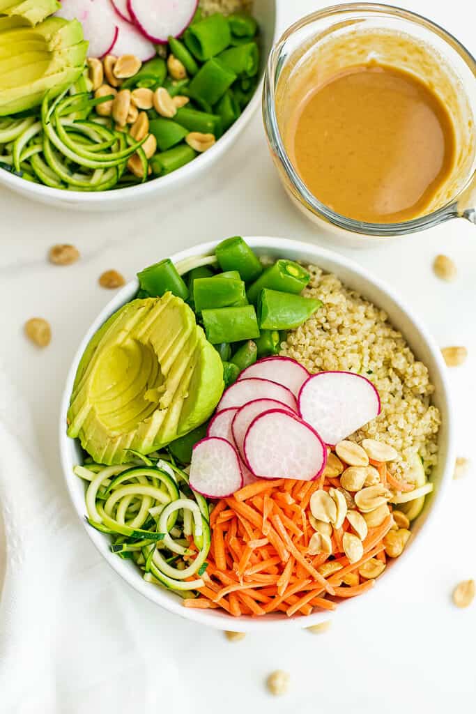 Asian zoodle buddha bowl in a white bowl with peanut dressing.