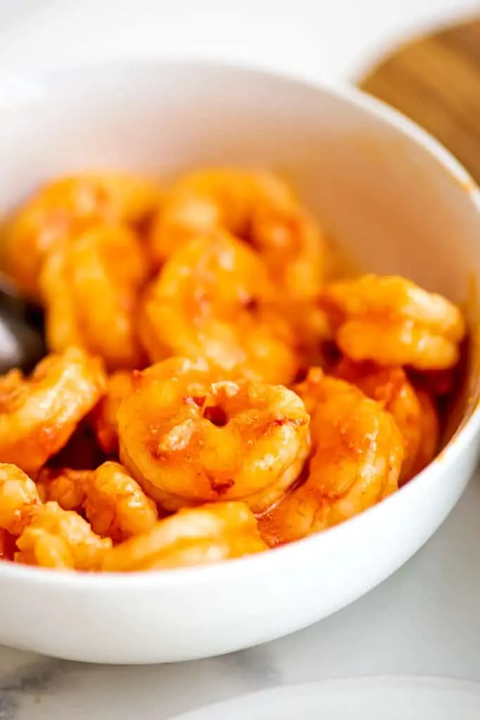 Bowl filled with buffalo grilled shrimp.