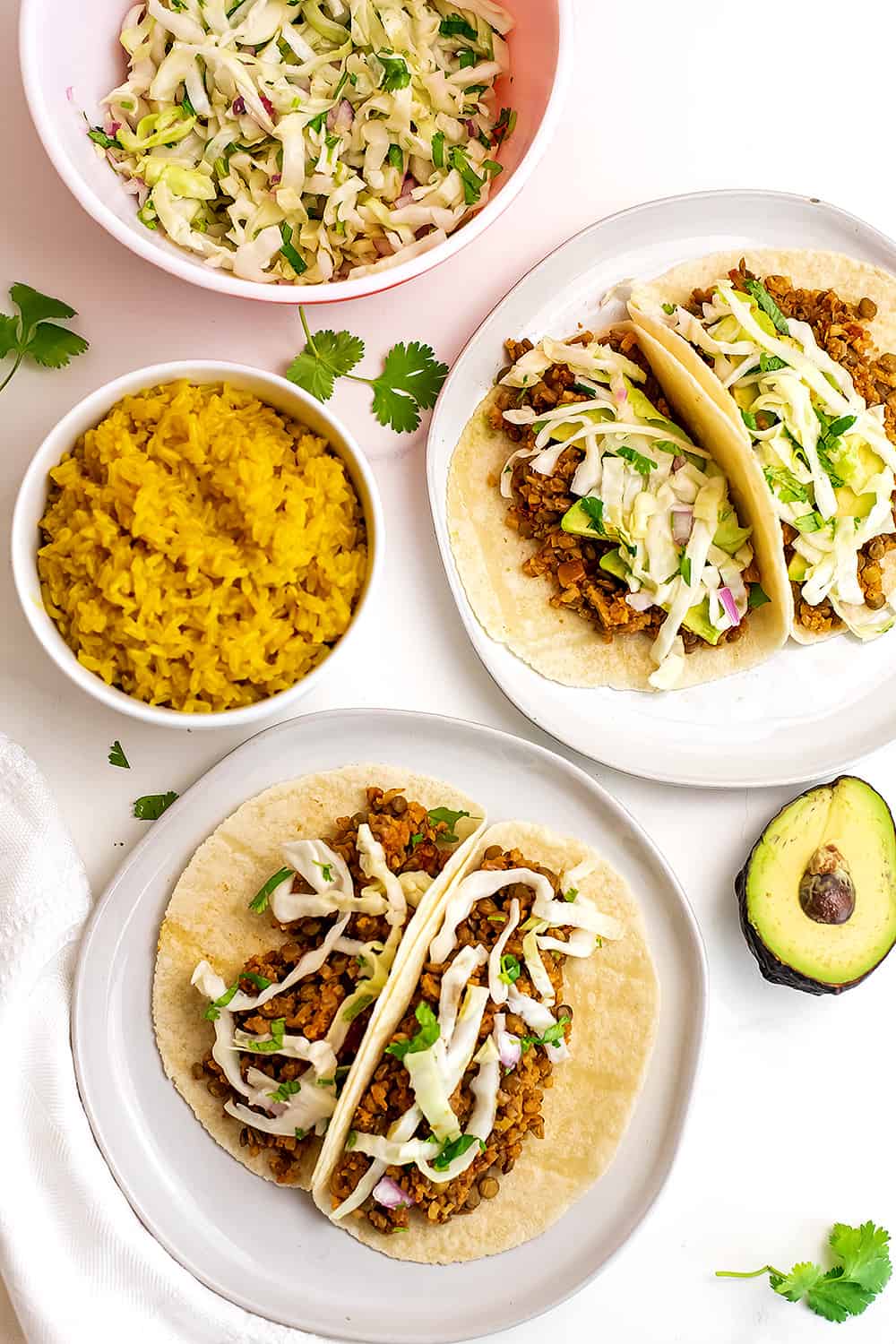 Lentil cauliflower tacos on plates with yellow rice.