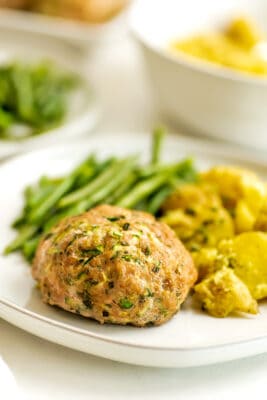 Ranch turkey meatlaof on a plate with potatoes and green beans.