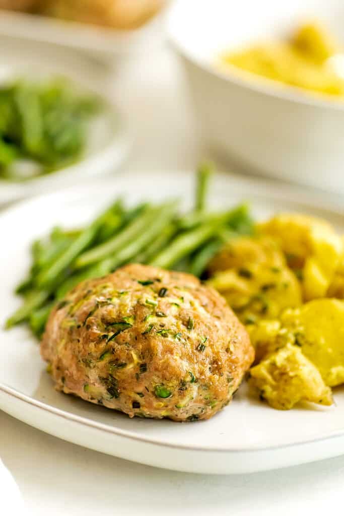 Ranch turkey meatlaof on a plate with potatoes and green beans.
