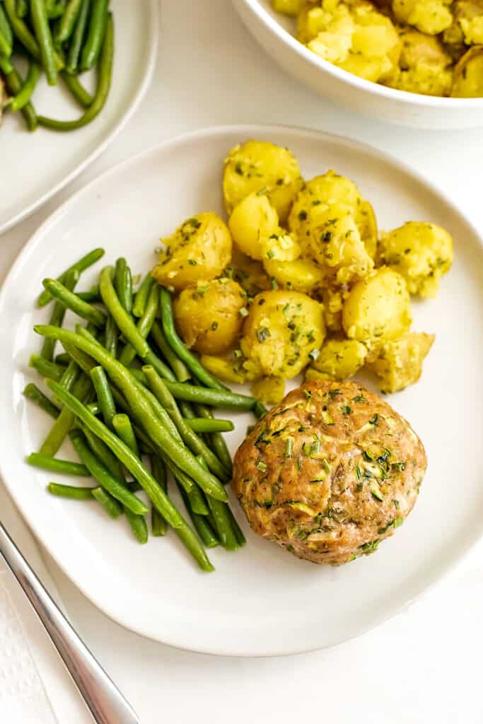 Ranch turkey meatloaf on a plate with green beans and golden potatoes.