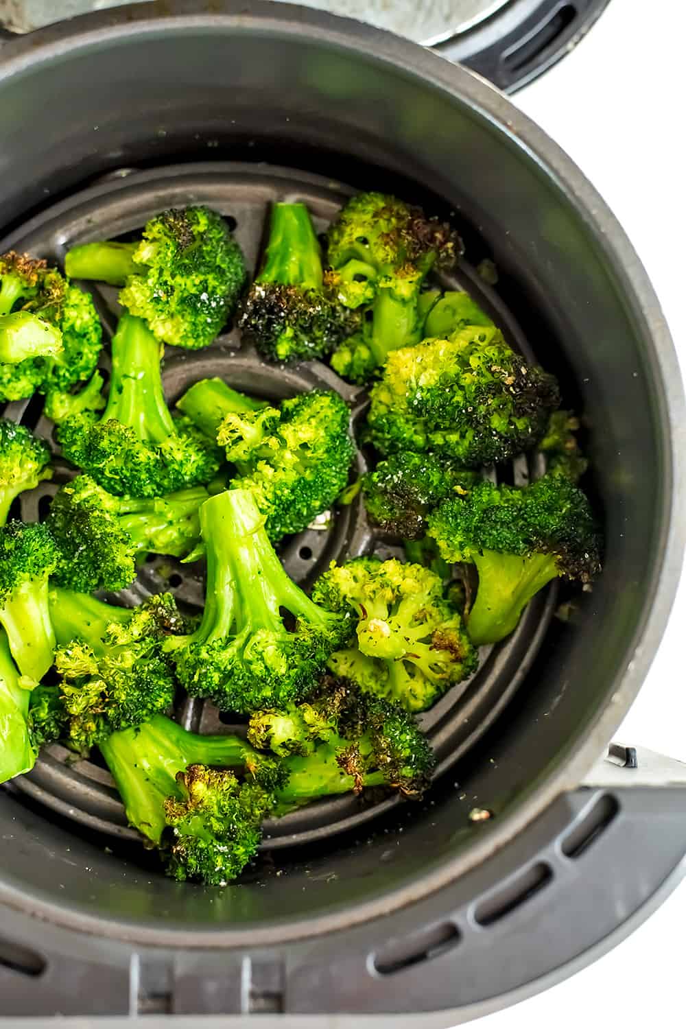 Air fryer frozen broccoli in air fryer after cooking. 