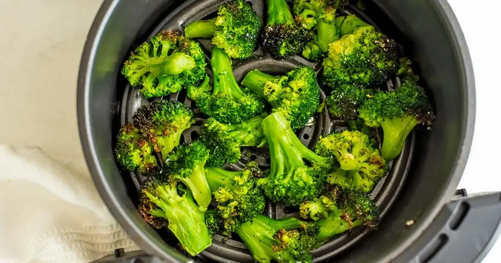 Air fryer frozen broccoli in air fryer after cooking.