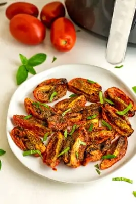 Air fryer tomatoes on a white plate.
