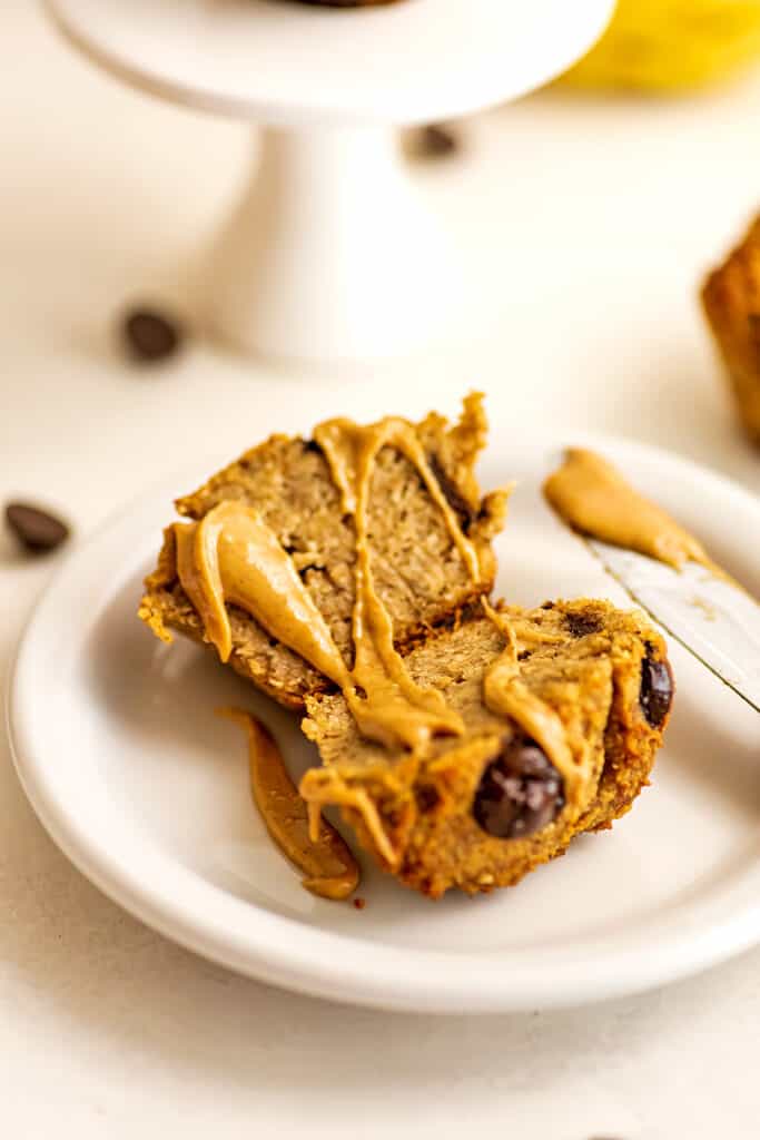 Almond flour banana muffin cut in half with peanut butter drizzled.