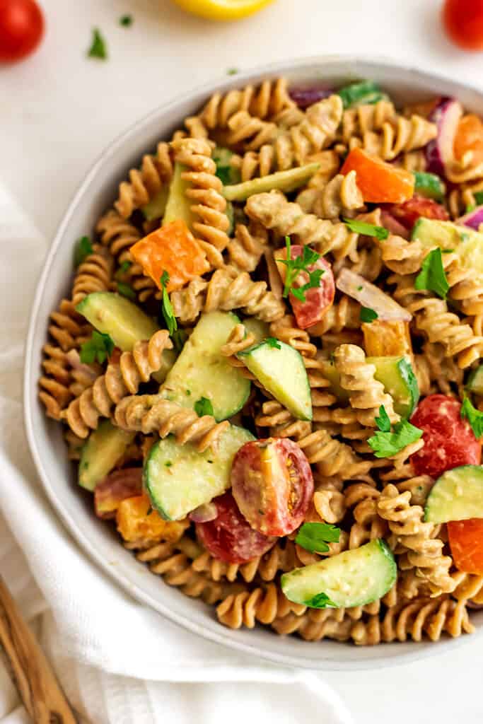 Hummus pasta salad in a large bowl with white napkin.
