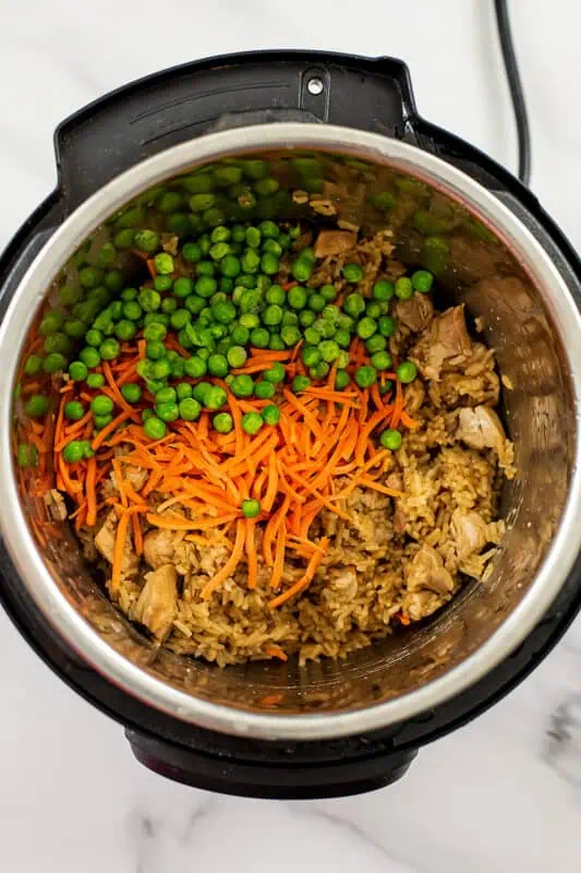 Shredded carrots and frozen peas added to instant pot.