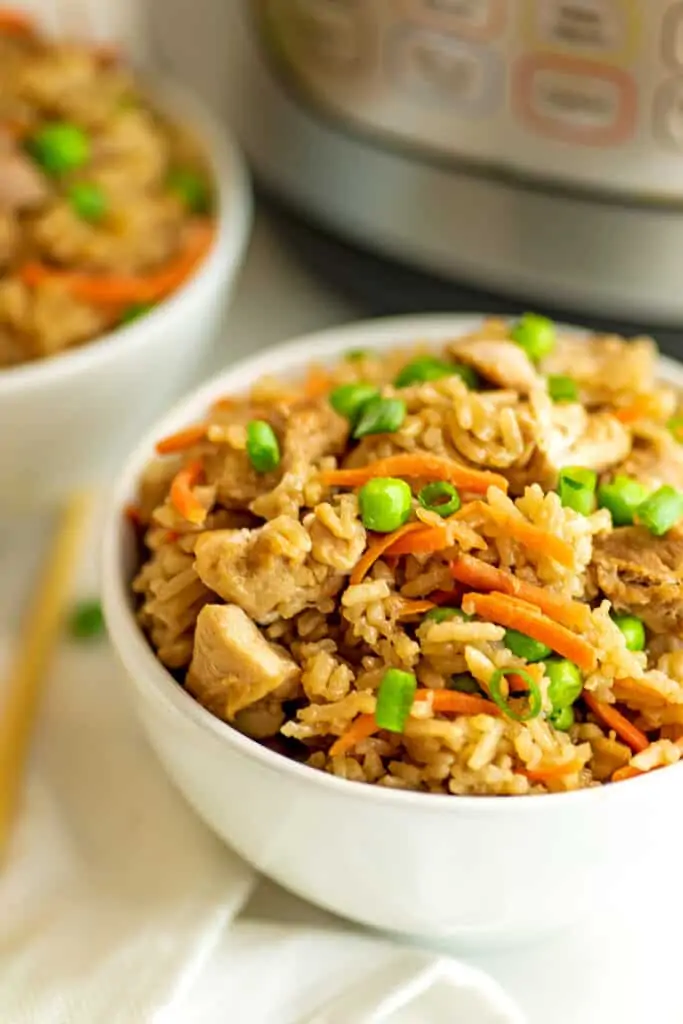 Chicken fried rice in a white bowl in front of instant pot.