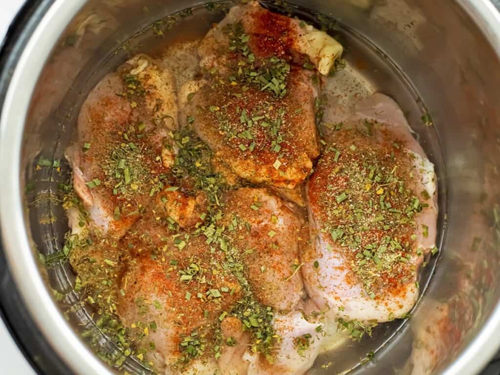 Chicken thighs with seasoning in instant pot.