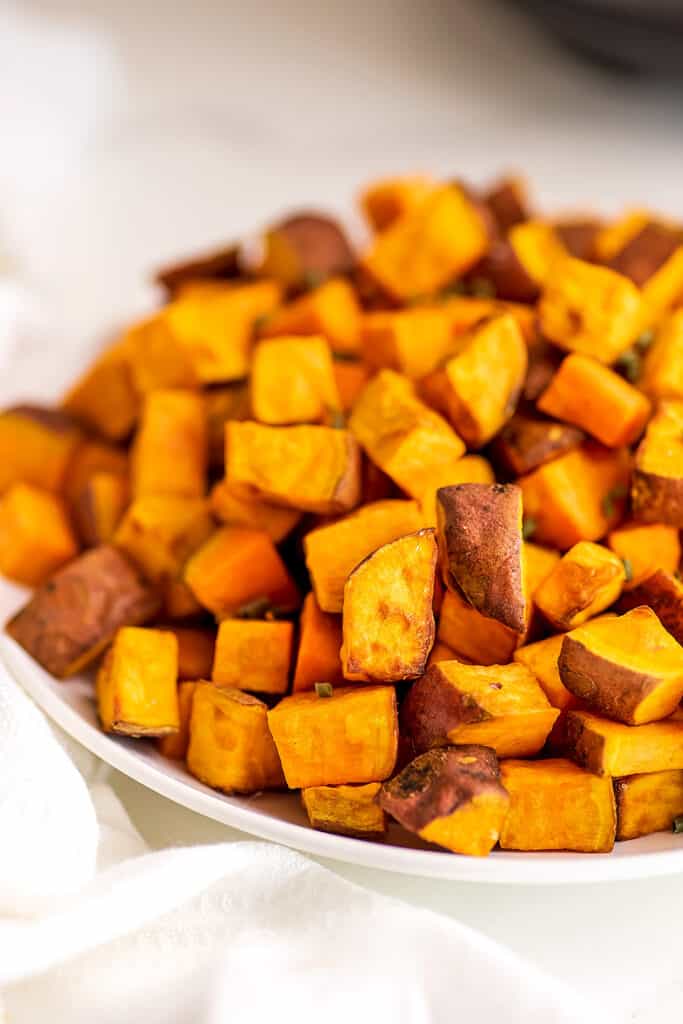 Air fryer sweet potato cubes in white bowl.
