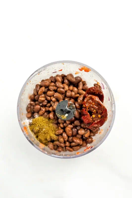 Small food processor with black beans, chipotle peppers and spices.